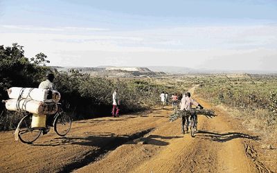 Villagers transport goods by bicycle along a poorly maintained road near the North Mara mine in Tanzania. Picture: Bloomberg